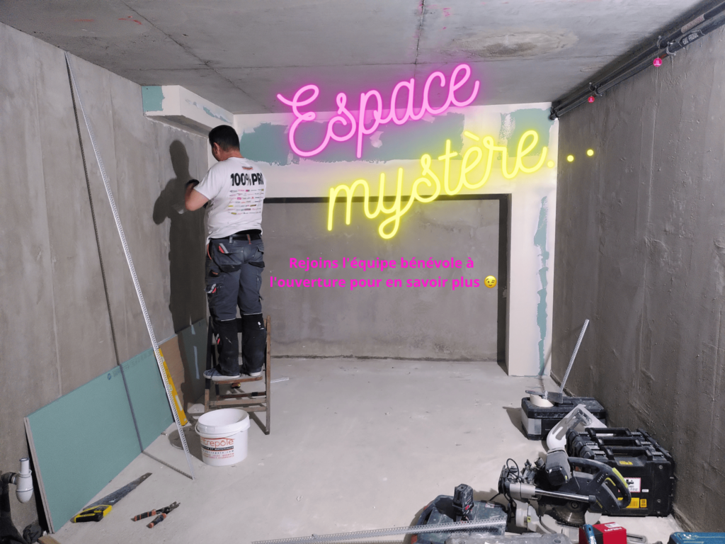 Dans l'atelier d'auto-réparation vélo de Paris 10 Paillettes et Cambouis,espace mystère où il se passera plein de trucs. On voit un ouvrirer qui s'occupe d'un mur en travaux.